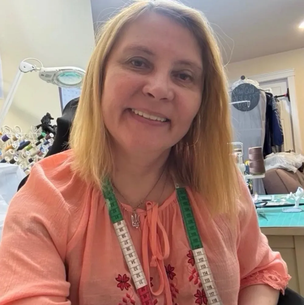Alla in her Comox sewing studio, a tape measure around her neck.